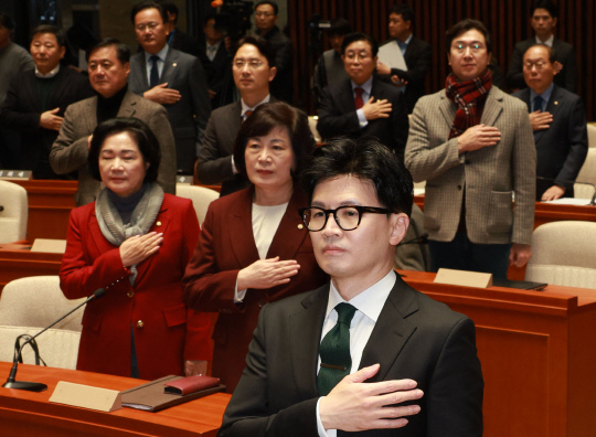 한동훈 법무부 장관과 국민의힘 의원들이 6일 국회 예결위회의장에서 열린 국민의힘 정책의원총회에서 국민의례를 하고 있다.연합뉴스